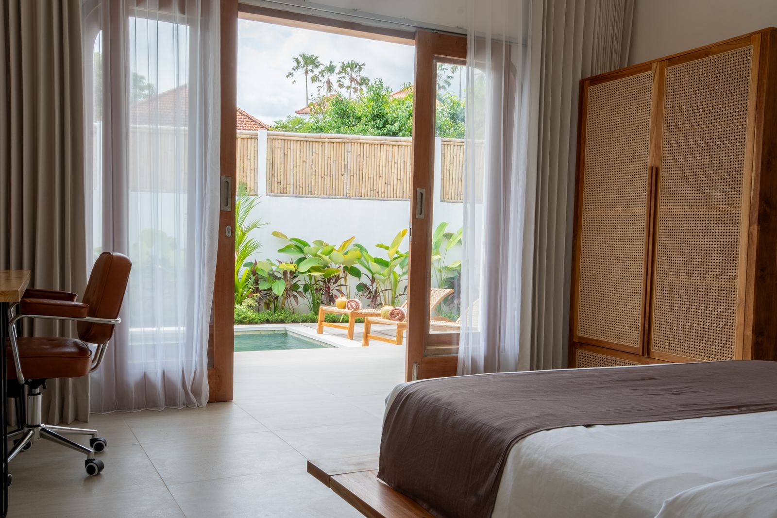 Bedroom with desk and doors to the pool